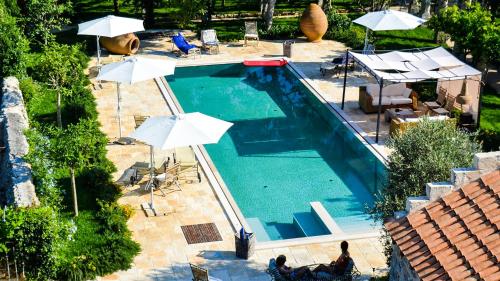 una vista aérea de una piscina con sombrillas en Palazzo Siena - Home & More en Minervino di Lecce