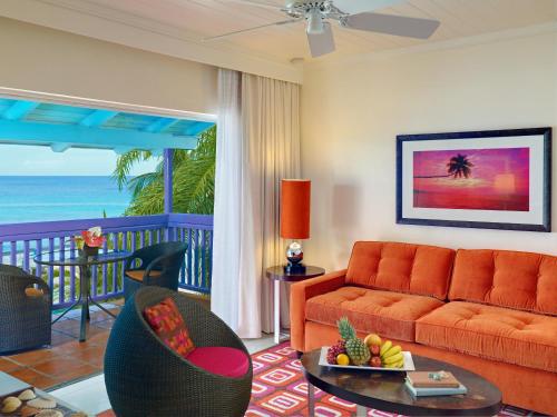 a living room with a couch and a balcony with the ocean at Crystal Cove, Barbados, A Tribute Portfolio All-Inclusive Resort in Saint James