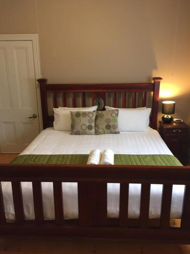 a bedroom with a wooden bed with white sheets and pillows at Little River Bed and Breakfast in Little River