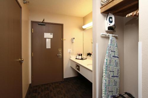 a bathroom with a sink and a toilet and a mirror at New Victorian Inn & Suites Lincoln in Lincoln