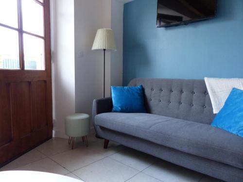 サン・ジョリオにあるMaison de charme " Les Cyclamens"のリビングルーム(青いソファ、ランプ付)