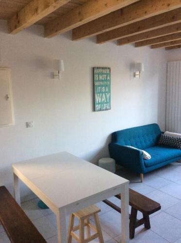 a living room with a blue couch and a table at Maison de charme " Les Cyclamens" in Saint-Jorioz