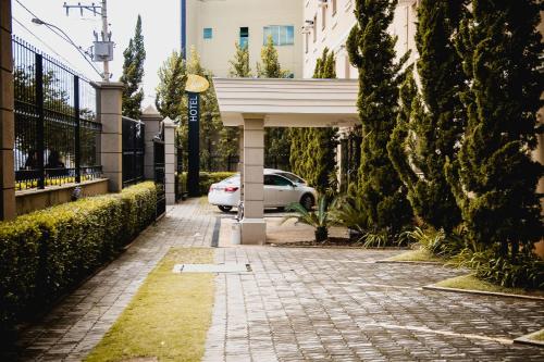 a sidewalk with a car parked under a building at Class Hotel Passos in Passos
