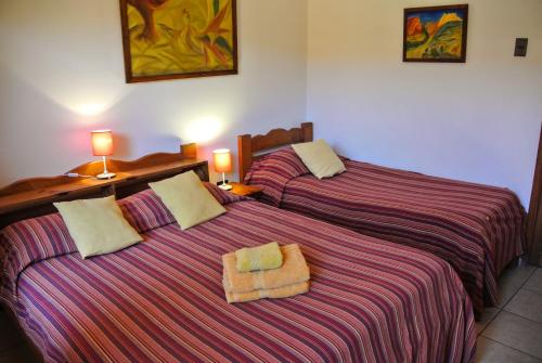 two beds sitting next to each other in a room at Hostal El Punto in La Serena