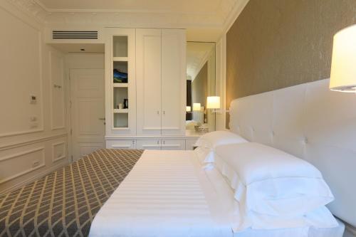 a bedroom with a large bed with white pillows at Grand Hotel Palace in Ancona