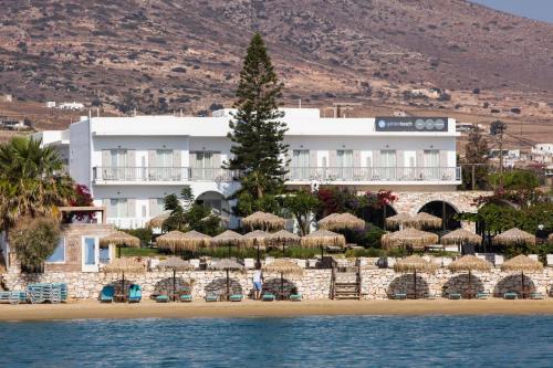 a hotel on the beach with chairs and umbrellas at Golden Beach Hotel in Chrissi Akti