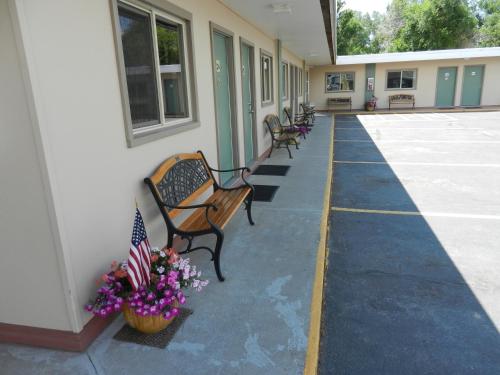 une rangée de bancs assis à l'extérieur d'un bâtiment dans l'établissement Paintbrush Motel, à Riverton