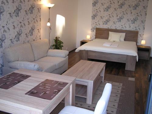 a small living room with a bed and a couch at Gonda Apartments in Hradec Králové
