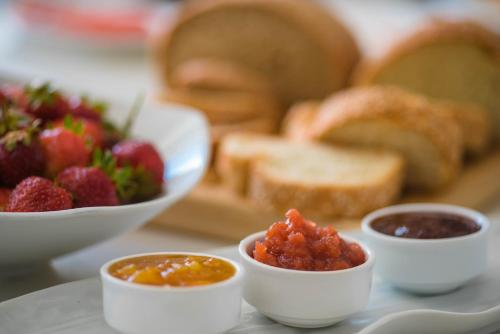 a plate of food with fruit and jam and bread at Golden Beach Hotel in Chrissi Akti