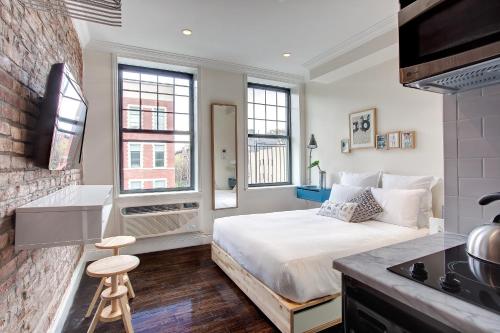 a bedroom with a bed and a brick wall at East Village Hotel in New York