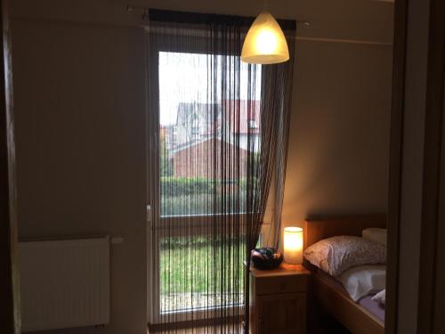 a bedroom with a window with a view of a bed at Apartament Ella in Międzywodzie