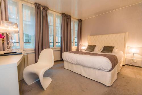 a bedroom with a bed and a white chair at Hotel Relais Saint Jean Troyes in Troyes
