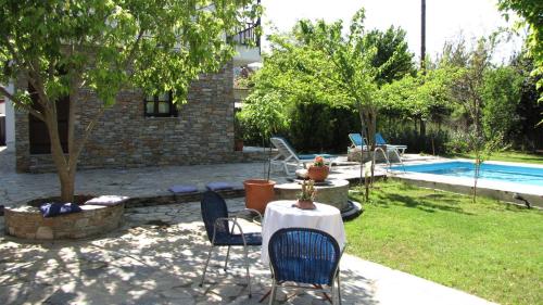 a patio with a table and chairs and a pool at EL Villa Pelion in Chorto