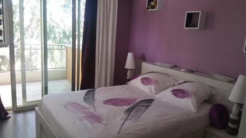 サン・ローラン・デュ・ヴァールにあるRoc et Galetsの紫の壁のベッドルーム1室、ベッド1台(枕付)