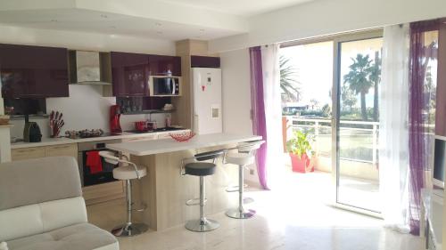 Il comprend une cuisine avec un comptoir et offre une vue sur un balcon. dans l'établissement Roc et Galets, à Saint-Laurent-du-Var