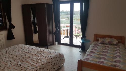 a bedroom with a bed and a view of a balcony at Apartments Sorgo in Novigrad Istria