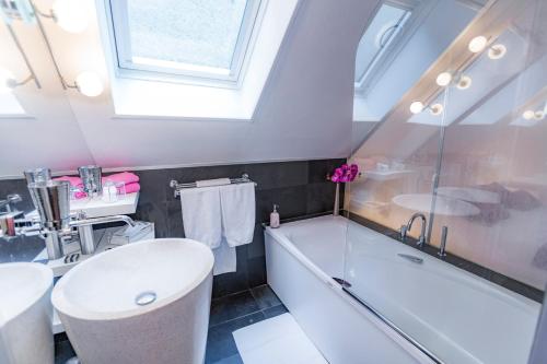 a bathroom with a tub and a toilet and a sink at Hotel Relais Saint Jean Troyes in Troyes