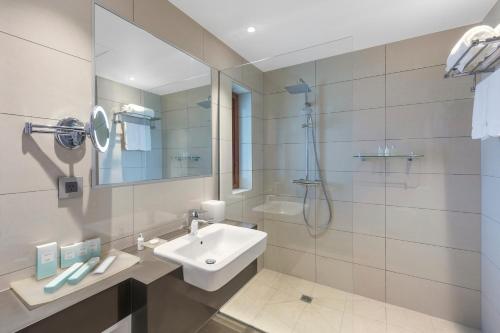 a white bathroom with a sink and a shower at Ramada Resort by Wyndham Port Vila in Port Vila