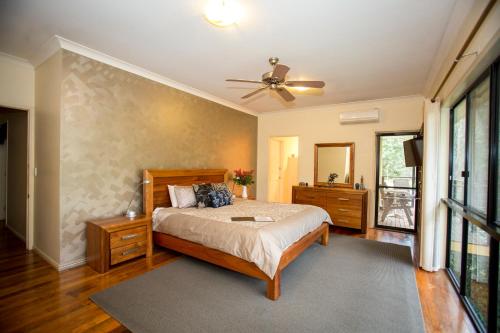 a bedroom with a bed and a ceiling fan at Mt Cotton Retreat in Mount Cotton