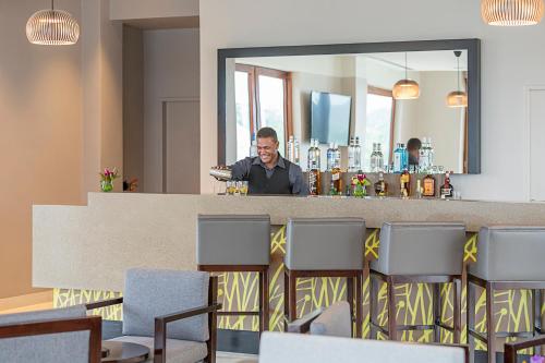 a man standing behind a bar with a mirror at Ramada Resort by Wyndham Port Vila in Port Vila
