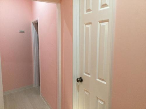 an open door in a room with pink walls at ラナイ ホテルアンドドミトリー in Naha