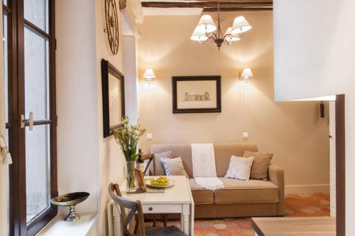 un salon avec un canapé et une table dans l'établissement Le Voyage En Isle, à Paris