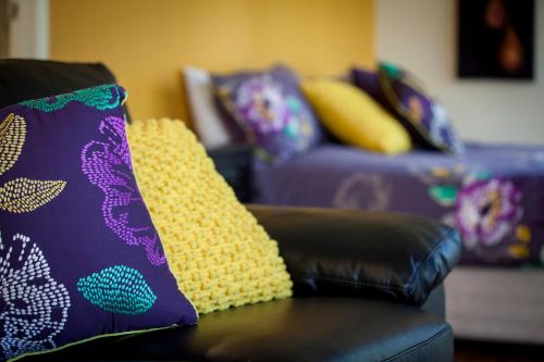 a couch with colorful pillows on top of it at Mt Cotton Retreat in Mount Cotton