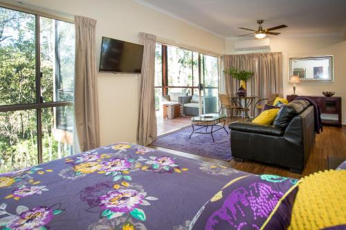 a bedroom with a bed and a living room with a couch at Mt Cotton Retreat in Mount Cotton