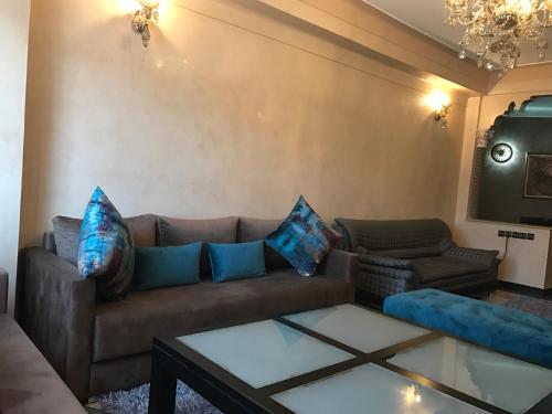 uma sala de estar com um sofá castanho e almofadas azuis em Sabor Apart Gueliz -Only Family- em Marrakech