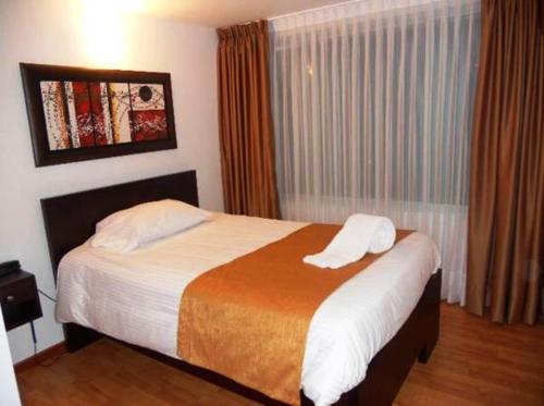 a bedroom with a bed and a window at Hotel Expo Inn Embajada in Bogotá