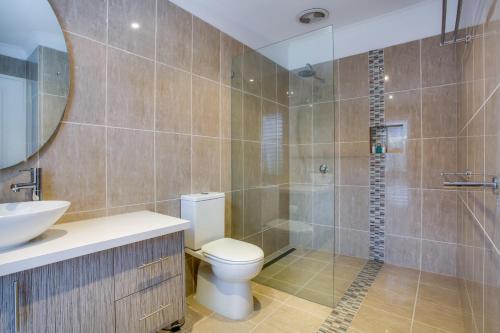 a bathroom with a toilet and a sink and a shower at Cute Cottage on Cain - beach at end of street in Rye