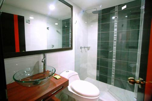 a bathroom with a sink and a toilet and a shower at Hotel Expo Inn Embajada in Bogotá