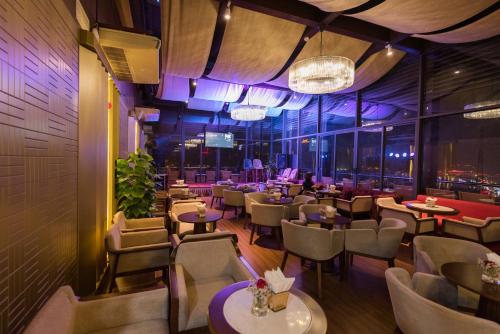 a restaurant with tables and chairs and purple lighting at Le Indochina Hotel in Bắc Ninh