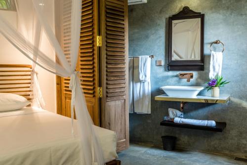 a bathroom with a sink and a bed and a mirror at Prince of Galle (inside the Fort) in Galle