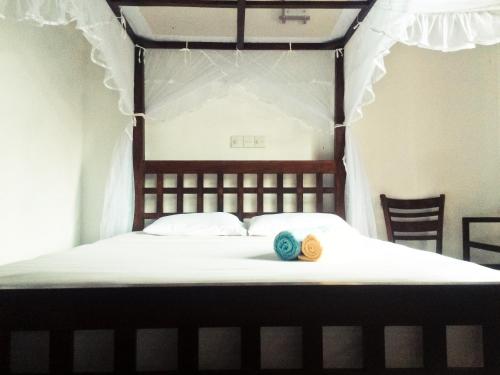a bedroom with a bed with a wooden head board at Opal Mirissa in Mirissa