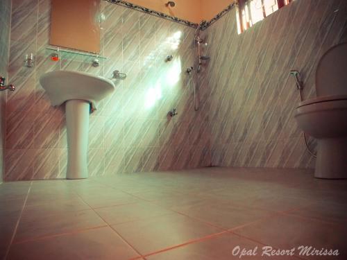 a bathroom with a sink and a toilet at Opal Mirissa in Mirissa