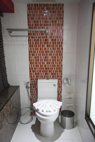 a bathroom with a white toilet in a shower at Grand Pink Hotel Hatyai in Hat Yai