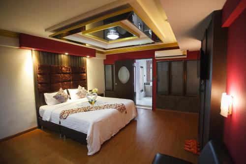 Grand Pink Hotel Hatyai في هات ياي: غرفة نوم بسرير كبير في غرفة