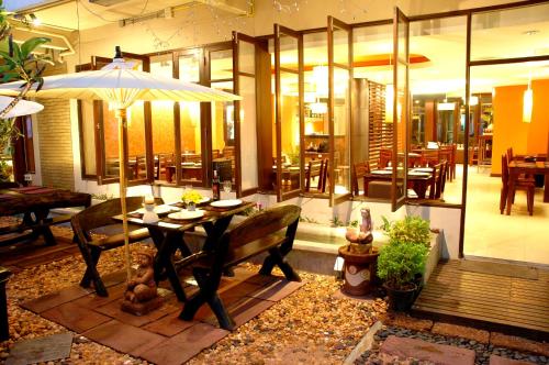 a dining room with a table and an umbrella at The Jomtien Twelve in Jomtien Beach