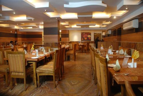 a dining room with wooden tables and chairs at Pan Asia Continental in Kolkata