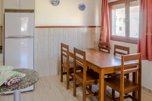 a kitchen with a wooden table and a refrigerator at Apartamentos Tesy in La Manga del Mar Menor
