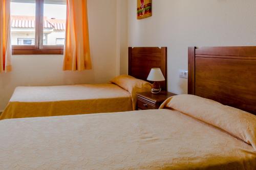 a hotel room with two beds and a window at Apartamentos Tesy in La Manga del Mar Menor