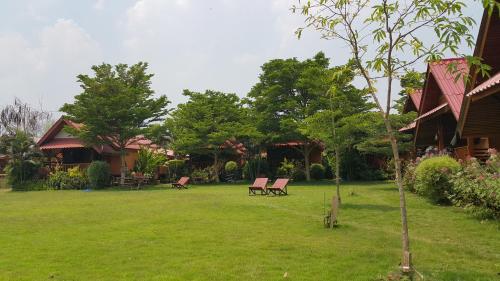 a yard with two chairs and a house at Phu View Guesthouse in Pai