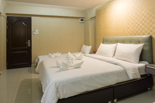 a bedroom with two beds with white pillows at NRC Residence in Lat Krabang
