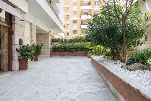 einen Innenhof eines Gebäudes mit Bäumen und Pflanzen in der Unterkunft Casa Tua Vaticano Guest House in Rom