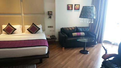 a hotel room with a bed and a couch at Ramada by Wyndham Navi Mumbai in Navi Mumbai