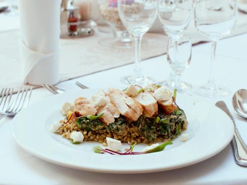 a plate of food on a table with wine glasses at Hotel Restauracja Autos in Solec Kujawski