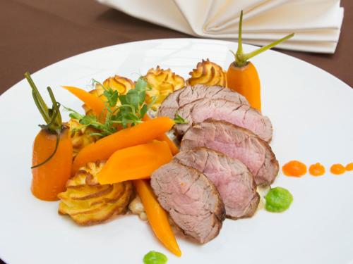 a white plate of food with meat and vegetables at Hotel Restauracja Autos in Solec Kujawski