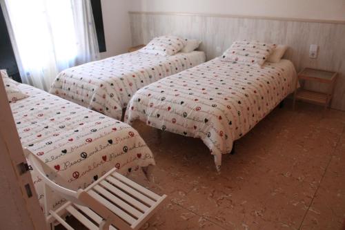 - une chambre avec deux lits et une chaise dans l'établissement Son Quimet, à Cadaqués