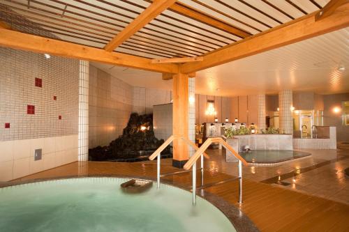 a hot tub in a room with a fireplace at Oehonke in Kitami